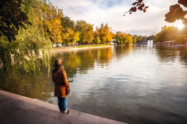 Mujer cerca del lago en el parque de otoño —  Fotos de Stock