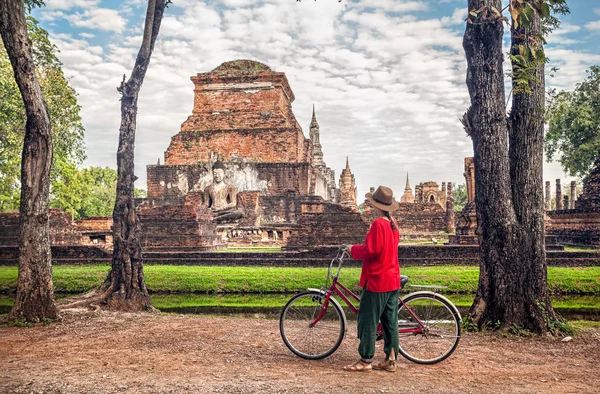 Kvinna med cykel nära temple i Thailand — Stockfoto