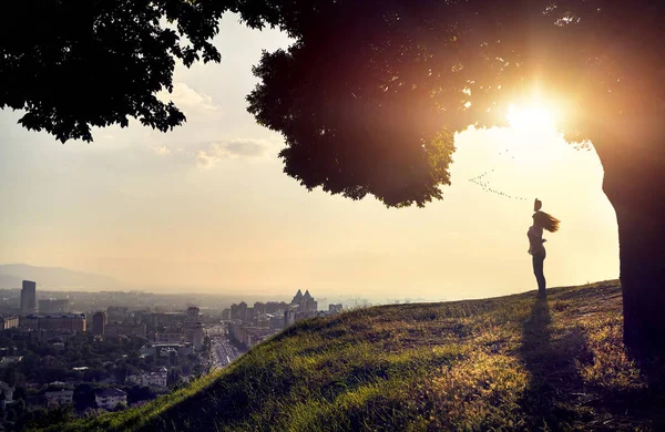 Silueta de mujer al atardecer vista a la ciudad —  Fotos de Stock