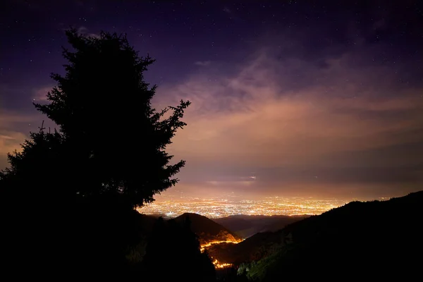 Gece şehir ve yıldızlı gökyüzünün — Stok fotoğraf