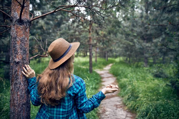 Kvinna i hatt med valnötter i skogen — Stockfoto