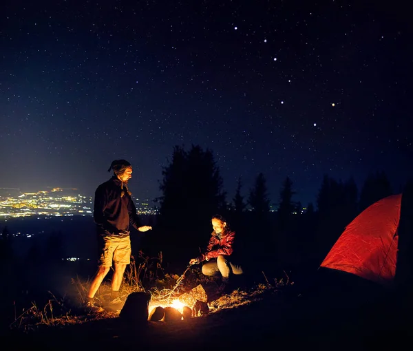 Romantiska par nära lägerelden på stjärnklart — Stockfoto