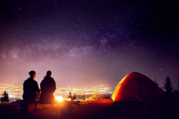 Casal romântico perto da fogueira no céu estrelado — Fotografia de Stock