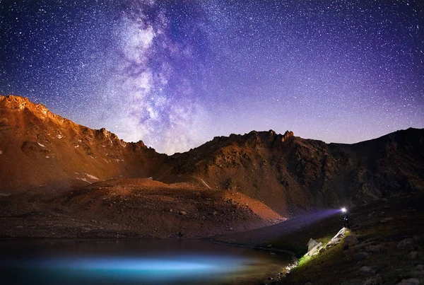 L'uomo con il faro in montagna di notte cielo — Foto Stock