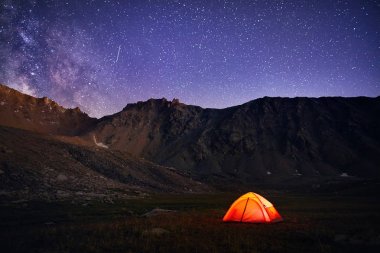 Turuncu çadır ışımalar gece gökyüzü altında 