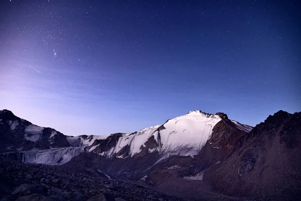 Pico de neve sob céu noturno — Fotografia de Stock