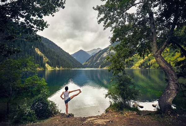 Mujer joven está practicando yoga al aire libre — Foto de Stock