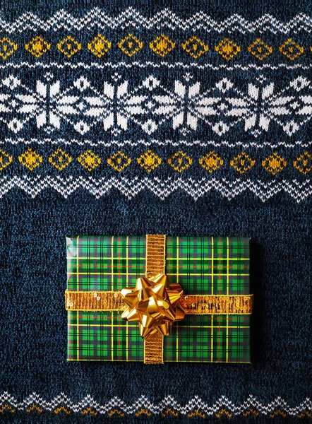 Green wrapped present on Christmas sweater — Stock Photo, Image