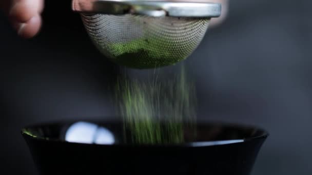 Matcha groene thee wordt gezeefd door een zeef — Stockvideo