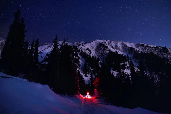 Man with bicycle at Winter Mountains at night — Stock Photo, Image