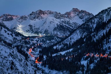 Medeu buz pateninden, Tian Shan dağlarındaki Shymbulak kayak merkezine, Kazakistan Almaty 'deki parlayan yolun manzarası.