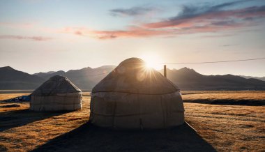 Yurt göçebe evleri Orta Asya 'da gün doğumunda dağ vadisinde kamp kurar.