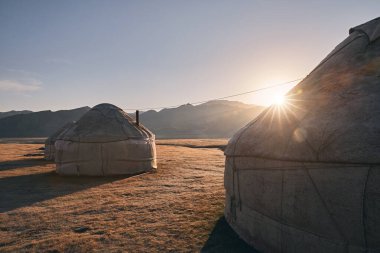 Yurt göçebe evleri Orta Asya 'da gün doğumunda dağ vadisinde kamp kurar.