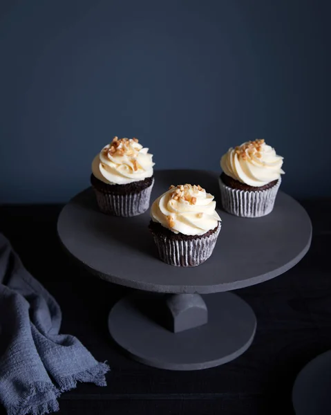 Cupcakes Chocolate Con Crema Mantequilla Blanca Cacahuetes Sobre Fondo Oscuro —  Fotos de Stock