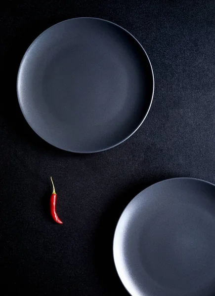 Composizione Minimalista Peperoncino Rosso Due Piatti Ceramica Nera Tavolo Nero — Foto Stock