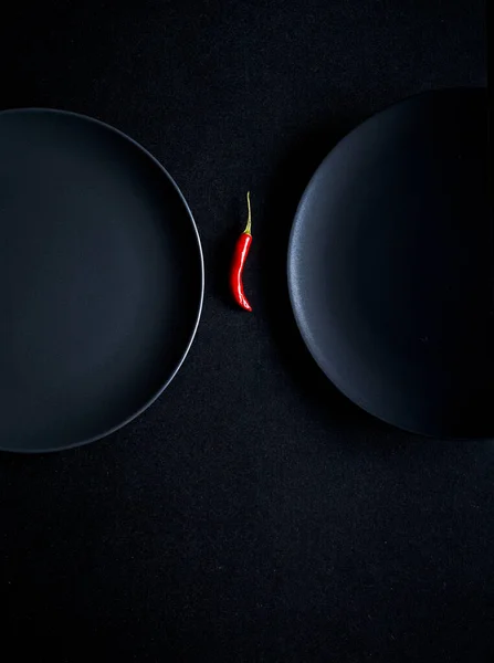 Composizione Minimalista Peperoncino Rosso Tra Due Piatti Ceramica Sfondo Nero — Foto Stock