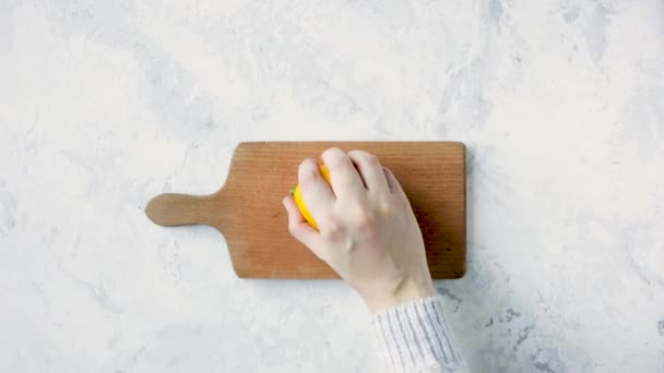 Vrouw snijdende citroen op houten plank — Stockvideo