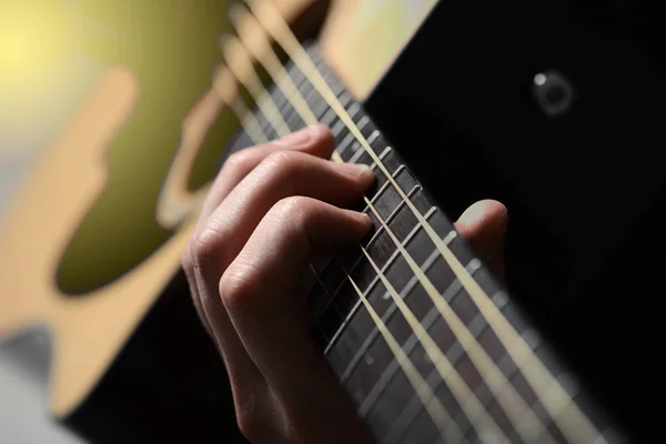 Mãos de homem tocando guitarra acústica — Fotografia de Stock