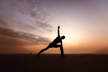 Sunset bulvarında Yoga yapan erkek. Ardha-Chandrasana'dan. Yan görünüm