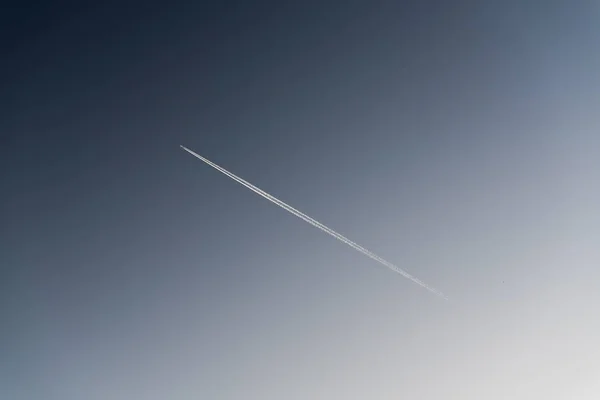Следы самолета на фоне голубого неба — стоковое фото
