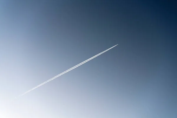 Следы самолета на фоне голубого неба — стоковое фото