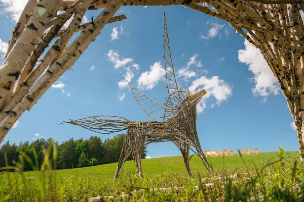 Land art horse with wings. Sculpture of branches