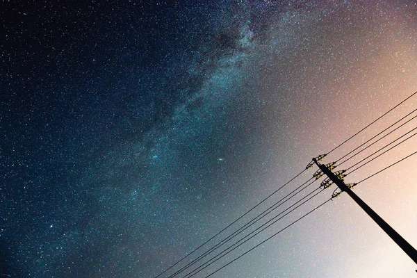 Abstraktní noční oblohu s mléčnou dráhu a hvězda nad siluetu elektrické vedení — Stock fotografie