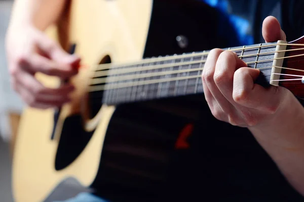 Las manos del hombre tocando la guitarra acústica — Foto de Stock