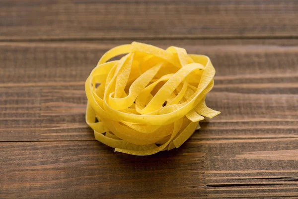 Pasta on a wooden background. Fettuccine — Stock Photo, Image