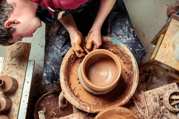 Potter at work. Workshop. Hands of a potter, creating an earthen jar on the circle — Stock Photo, Image