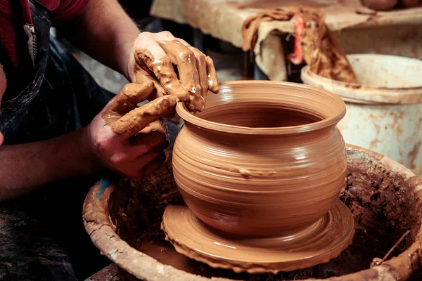 Potter at work. Workshop. Hands of a potter, creating an earthen jar on the circle — Stock Photo, Image
