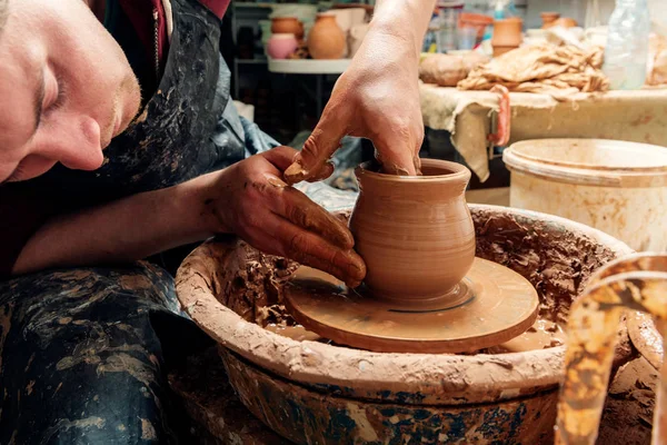 Potter en el trabajo. Taller. Manos de un alfarero, creando un frasco de tierra en el círculo — Foto de Stock