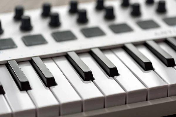 Vit MIDI-keyboard med kuddar och reglar. — Stockfoto
