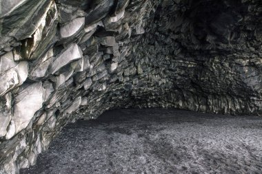 İzlanda'daki siyah bir plajda mağara.