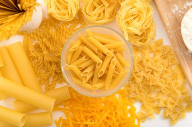 Ahşap arka plan üzerinde makarna çeşitleri. Farfalle, fettuccine, erişte, düdük ve penne rigate. Lezzetli İtalyan yemekleri.