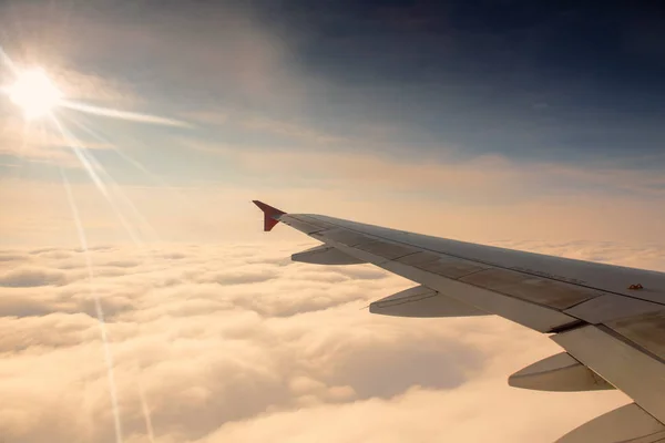 Ala de avião com nascer do sol e céu azul . — Fotografia de Stock