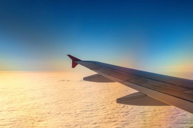Gündoğumu ve mavi gökyüzü ile uçağın kanat.