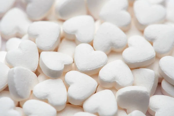 Pharmacy theme. White pills in the form of hearts on white background. — Stock Photo, Image