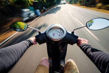 Scooter sürüş bir asfalt yolda binici. Bulanık hareket backgro