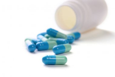 Beyaz arka plan üzerinde şişeyle hapları