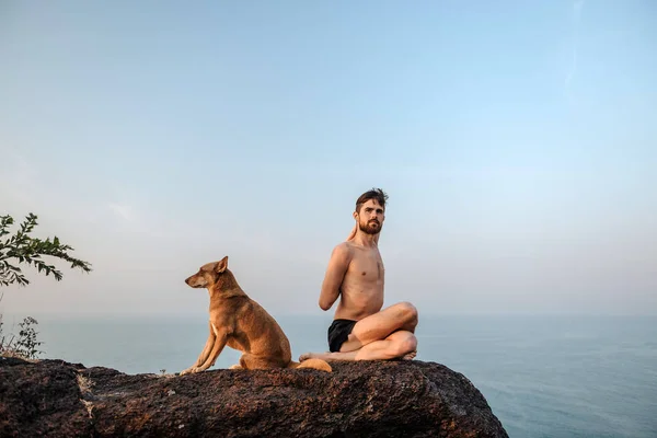 Healthy man practicing yoga under the beach at sunset. — Stock Photo, Image