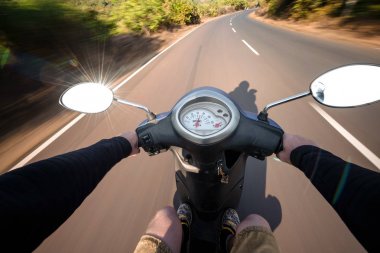 Scooter sürüş bir asfalt yolda binici. Bulanık hareket backgro