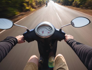 Scooter sürüş bir asfalt yolda binici. Bulanık hareket backgro