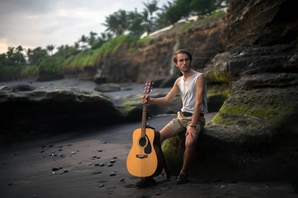 Romantic young man with a guitar on the beach — Stock Photo, Image