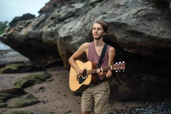 Romantic young man with a guitar on the beach — Stock Photo, Image