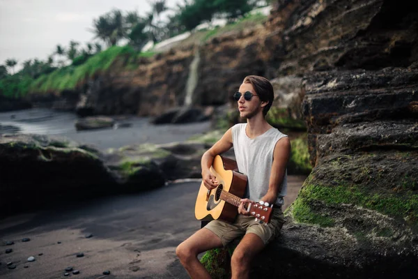 Romantische jongeman met een gitaar op het strand — Stockfoto