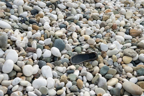 Schuhsohle an einem felsigen Strand. — Stockfoto