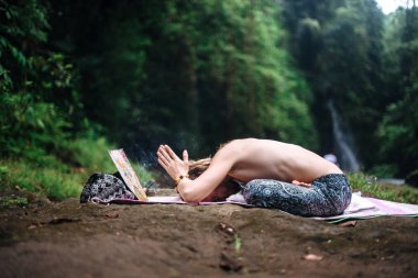 Yoga uygulaması ve doğada meditasyon. Nehir yakınlarında pratik yapan adam