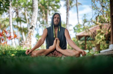 Erkek, dışarıda yoga ve meditasyon pratiği yapıyor.