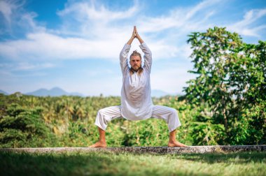 Erkek, dışarıda yoga ve meditasyon pratiği yapıyor.